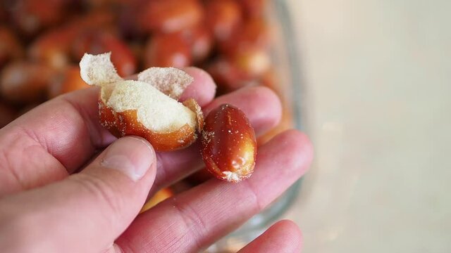 a person displays the natural and ripe oleaster fruits in his hand,