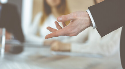 Business presentation. Unknown businessman giving a speech to colleagues or partners at corporate conference. Meeting concept