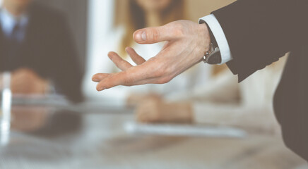 Fototapeta premium Business presentation. Unknown businessman giving a speech to colleagues or partners at corporate conference. Meeting concept