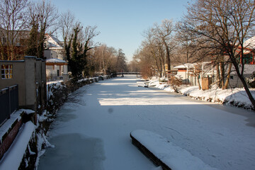 Fototapeta na wymiar Winter view of the icy and snowy park and river landscapes in Leipzig, Saxony, Germany b