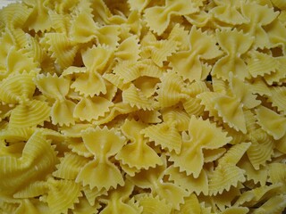 pasta in the form of bows in a glass container on a wooden background. High quality photo