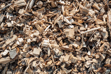 Closeup of a large heap of shredded wood after the felling of a large number of tall trees. The heap is waiting for transport to the combined heat and power plant.