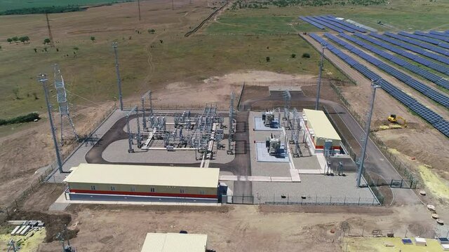 Fly over the field of solar panels and over the generator