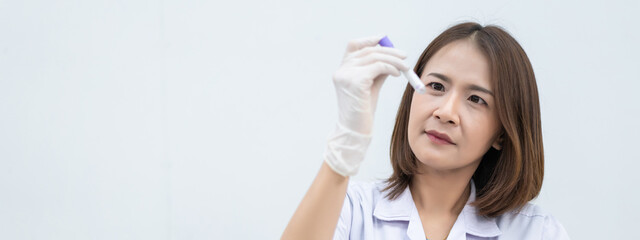A young woman researcher, doctor, scientist, or laboratory assistant working with plastic medical tubes to research, examine scientific experiments in a modern laboratory. Education stock photo