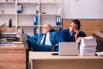 Old male boss and his young male assistant in bullying concept