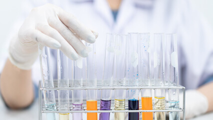 A young woman researcher, doctor, scientist, or laboratory assistant working with plastic medical tubes to research, examine scientific experiments in a modern laboratory. Education stock photo