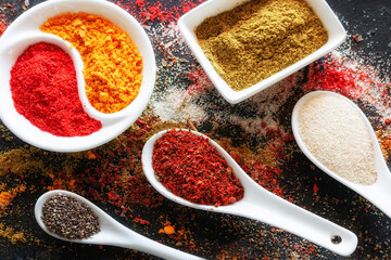 sprinkled multicolored spices on a black background