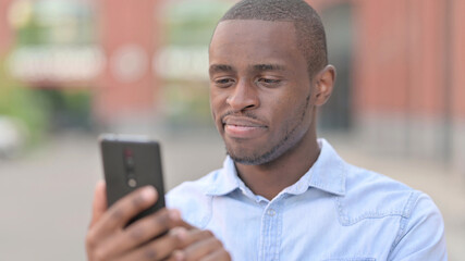 Portrait of Positive African Man using Smartphone 