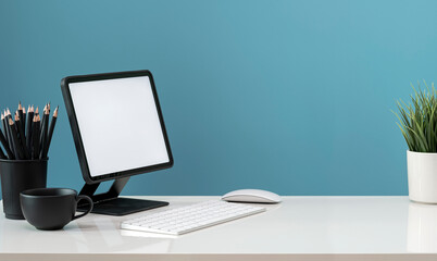 Creative workspace with tablet on stand with keyboard on the table.