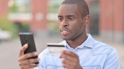 Portrait of African Man making Online Payment on Smartphone