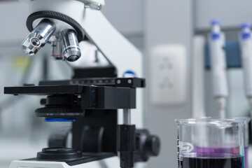 Close-up and selective focus shoot of a microscope, medical test tubes with liquid, and other modern laboratory equipment in a laboratory room. Education stock photo