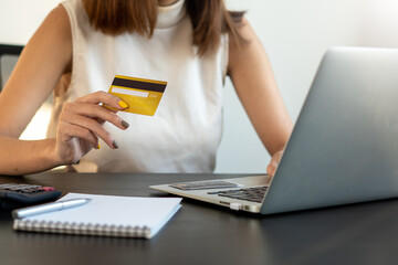 Young Asian woman using credit card for online shopping in coworking space, technology money wallet and online payment concept, credit card mockup