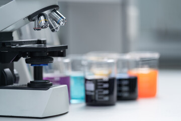 Close-up and selective focus shoot of a microscope, medical test tubes with liquid, and other modern laboratory equipment in a laboratory room. Education stock photo