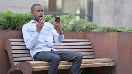 Fototapeta premium Upset African Man having Loss on Smartphone Outdoor 