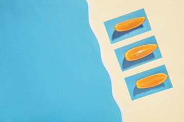 Fototapeta premium Three oranges sunbathe on the beach near the sea