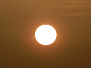 The sun, in the early hours of the day, offering orange and dark tones, dawning. 