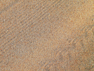 Background, beach sand with different shades of its tiny stones.	