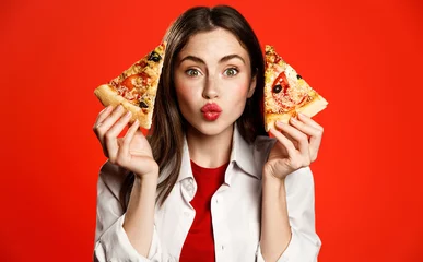 Foto auf Glas Cute girl shows two slices of delicious pizza takeaway, making kissing face, loves pizzeria fastfood, enjoys ordering food delivery at home, eating lunch from favorite restaurant while on lockdown © Liubov Levytska