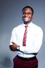 Smiling african american businessman in white shirt and tie looking at camera with arms crossed