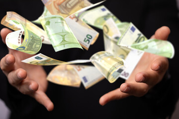 euro bills flying around  in hand