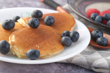 Tasty meal with berries and pan cake in bowl on black background