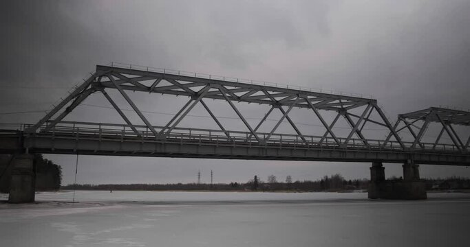 bridge over the river in the village of Ust-Luga on a cloudy winter day