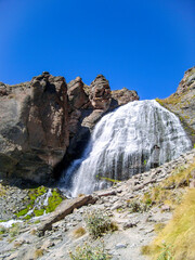 The fast flowing Waterfall . The water flows over a rocky cliff