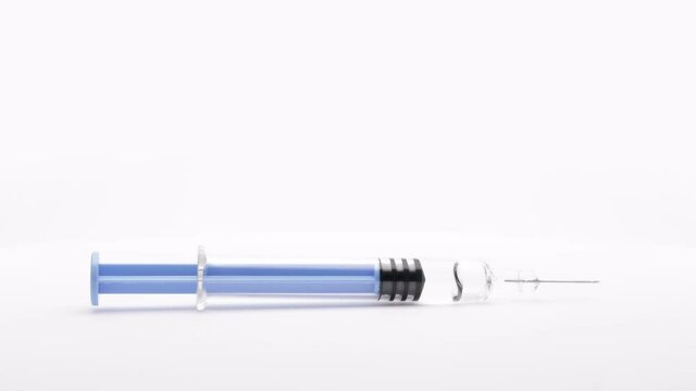 syringe with the vaccine or medical supplies on a white background (looping)