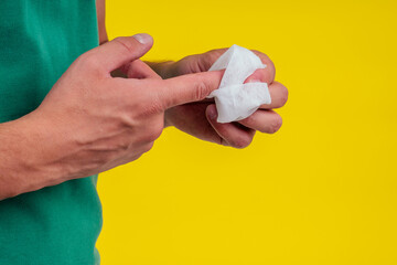 man holding bottle of sun cream in studio yellow background