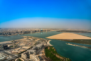 Abu Dhabi, United Arab Emirates, March 2021, Aerial view around Yas Island and Al Raha creek with Al Sail Tower building and Aldar headquarter building in the background 