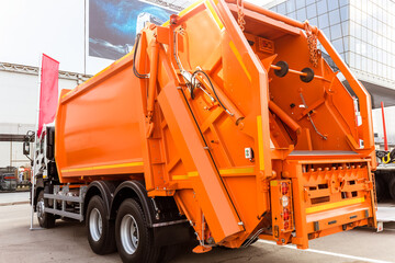 Orange car for collecting and transporting solid waste.