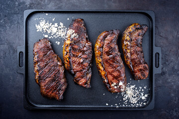 Modern style barbecue dry aged wagyu Brazilian picanha steaks from the sirloin cap of rump beef sliced and served as top view on a cast-iron design tray with copy space