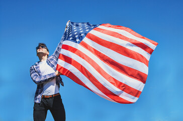 proud strong american man  waving USA united state  flag against blue sky
