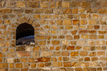 Background of the old stone wall with a loophole