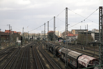 Fototapeta na wymiar train railroad tracks with parking wagons and electric power lines, symbol for urban vibes and industry