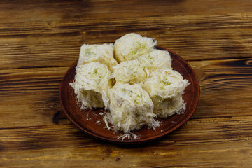 Traditional Turkish dessert Pismaniye with pistachios on wooden table
