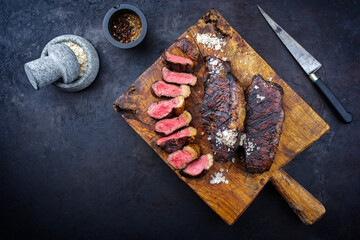 Traditional barbecue dry aged wagyu Brazilian picanha steaks from the sirloin cap of rump beef sliced and served as top view on a rustic wooden board