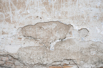 texture of an old peeling white wall, cracks, peeled off plaster