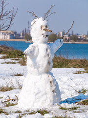 Snowman made from the last snow of the winter. Melting snow on a snowman
