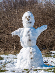 Snowman made from the last snow of the winter. Melting snow on a snowman