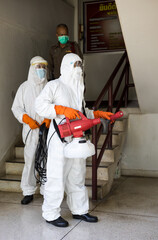 Both men, wearing PPE uniforms, sprayed cleaning the stairs.