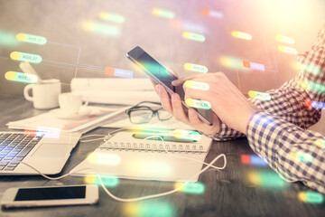 Double exposure of man's hand holding and using a digital device and data theme hologram drawing. Technology concept.