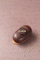 Contemporary Mini Mousse Cakes, covered in chocolate, decorated with chocolate elements, on a brown background.