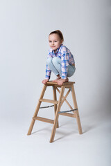 preschooler in regular clothes sits on a chair squatting