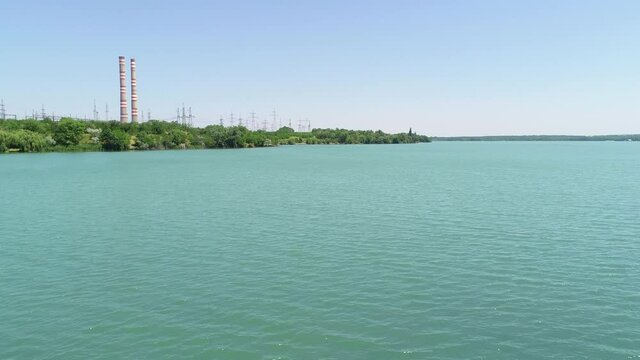 Flight over the lake to the factory chimney