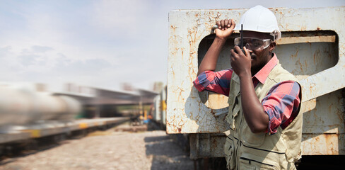 A black foreman holding the walkie-talkie.