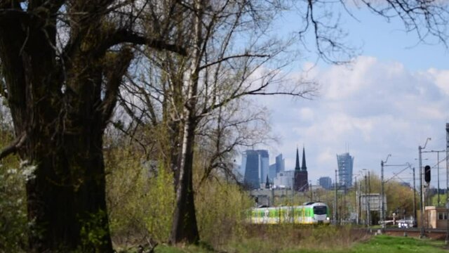 Pociąg osobowy kolej Mazowieckich przy stacji Warszawa Wileńska. Panorama Warszawy w słoneczny dzień z okolic Alei Solidarności