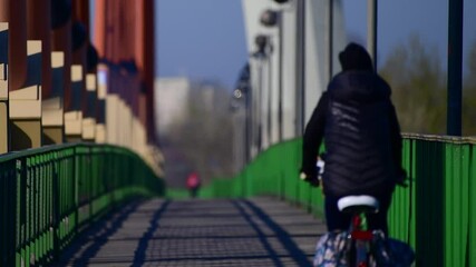 Warszawa trasa rowerowa przez most Siekierkowski. Wiosennym porankiem ludzie jadą do pracy