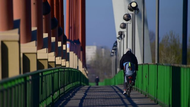 Warszawa trasa rowerowa przez most Siekierkowski. Wiosennym porankiem ludzie jadą do pracy