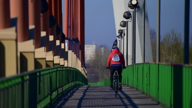 Warszawa trasa rowerowa przez most Siekierkowski. Wiosennym porankiem ludzie jadą do pracy